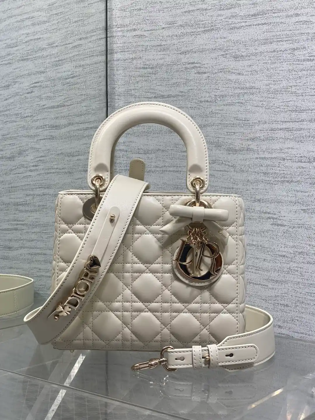 Dior Lady Dior: Tasche aus weißem Cannage-Leder mit Bügelgriff und D.I.O.R.-Anhängern.