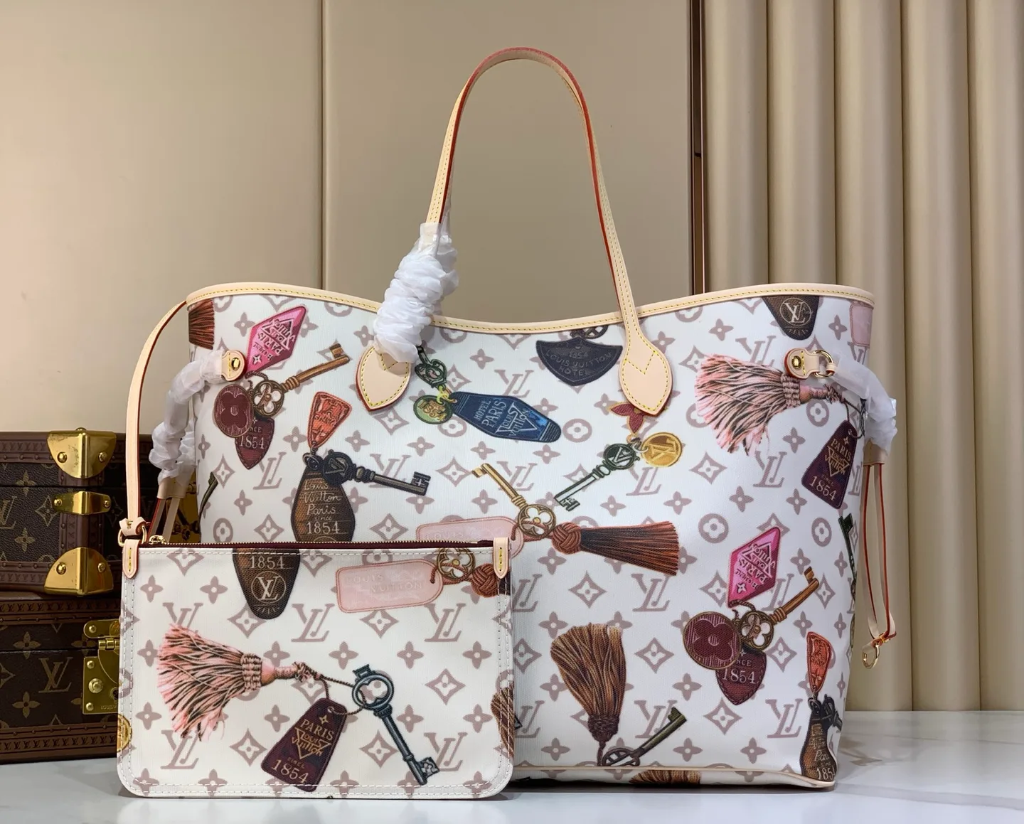 Louis Vuitton Neverfull: geantă tote din pânză Monogram albă, cu imprimeu de brelocuri și ciucuri.